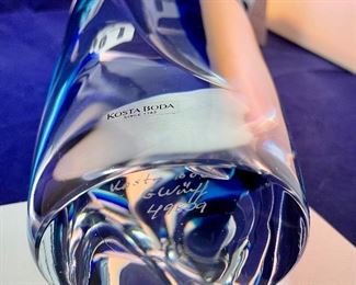 Lot 5128. $300.00. Kosta Boda Swedish Studio Art Glass pair, the first item is a Kosta Boda  by Gorän Warff Crystal Vase with contemporary beautiful lines and striking colors (11"t x 4"w) #49809, and a Kosta Boda heart beat art glass paperweight (3"x3"x1") by Bertil Vallien #90117 (both with boxes)