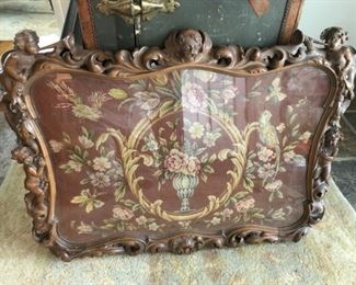 Fabulous framed needle point with putti carvings.