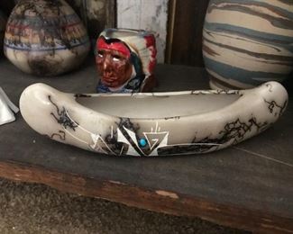 This canoe and several other items among the pottery were made with horsehair added to the glaze coat. That is a piece of turquoise embedded in the finish.