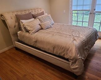 Side view of queen bed with cushioned headboard. Bedding is also available for purchase