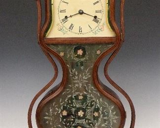A 19th century J. C. Brown "Acorn" model shelf clock.   8-day spring driven double fusee movement with Lyre shaped plates marked "Forestville M F G Co., Bristol, CT, U. S. A." painted metal dial with Roman numerals and coiled gong strike.  Mixed wood laminated case and arms with a single shaped door having conforming upper glass and two part lower glass with reverse painted decoration, on a molded base.  Old finish has been cleaned and waxed, dial with craquelure and some touchups, case has been reinforced with some added screws and bolts into the fusee bracket, running when cataloged.  24 1/2" high overall.  ESTIMATE $3,000-4,000
