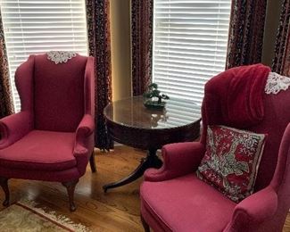 Pair of burgundy chairs, drum table with glass top, rug