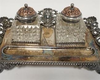 1104	VICTORIAN SILVER PLATED INKWELL SET W/ TWO CUT GLASS INKWELLS, SOME CHIPPING ON GLASS. 12 IN W 8 IN DEEP 5 1/2 IN H 
