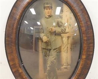 1144	PHOTO OF A SOLDIER IN OVAL CONVEX GLASS FRAME. SOME FRAME DAMAGE. 18 3/4 IN X 24 3/4 IN INCLUDING FRAME 
