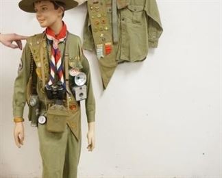 1225	MANNEQUIN CLOTHED IN BOY SCOUTS UNIFORM, SASH W/ PATCHES, BOY SCOUTS CAMERA, CANTEEN, FLASH LIGHT, BOY SCOUTS FIRST AIDE KIT, SCARF W/ A CLIP THAT READS *DISTRICT CAMPOREE 1949* A BOY SCOUTS HAT. IT IS CARRYING A KNAPSACK WHICH CONTAINS MORE BOY SCOUTS RELATED ITEMS INCLUDING A BOY SCOUTS UNIFORM, A 1977 BOY SCOUTS OF AMERICA JAMBOREE COMMEMORTIVE COIN, A LETTER OPENER, A FLAG & ANOTHER CANTEEN. ETC. LOT ALSO INCLUDES THREE ADDITIONAL BOY SCOUTS UNIFORM SHIRTS. MANNEQUIN IS APP. 59 IN TALL. MANNEQUIN MAY SUFFER LOSS TO FACE/BODY.  
