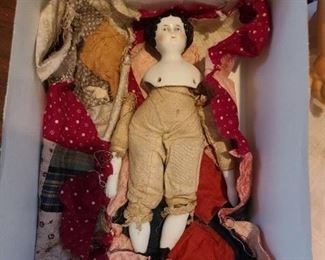 1800's porcelain head, arms, and legs. With clothing that is well used.