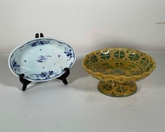 Lot 129 | (2pc) PAINTED CERAMICS | Including a yellow and green Italian pedestal dish (h. 4 x dia. 9 in.) and an oval dish from Holland decorated with floral motifs in blue underglaze