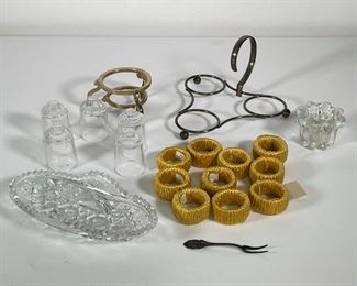 Lot 131 | (20pc) MISC. TABLEWARE | Including a set of 10 napkin rings, 5 matching glass pieces, 2 silver-toned stands, a silver-toned pickle fork, cut glass oval dish (w. 8 in.), and a small votive candle holder 