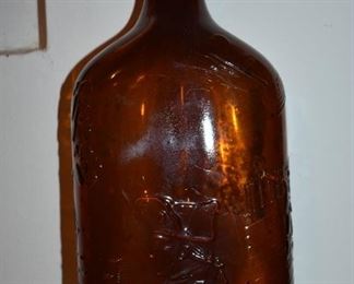 Antique Amber One Pint Liquor Bottle with George Washingtons Portrait Embossed on the Front. On the bottom are the numbers 011, 57-42, , Des. Pat. 7309 and the number 12 on the bottom edge