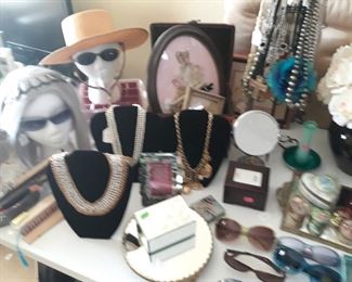 Costume jewelry, hats, new wig, antique framed ribbon paper doll, framed needlepoint, framed pressed flower, jewelry boxes, and vintage fans.