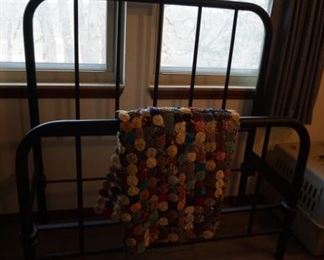 iron bed made into a quilt rack