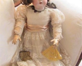 26. $200  German Doll with porcelain head, wearing jewelry and handbag, 28” 