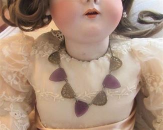 26. $200  German Doll with porcelain head, wearing jewelry and handbag, 28”
