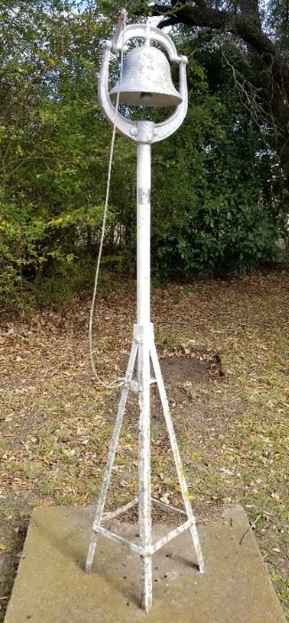 Vintage iron bell on stand and concrete pad