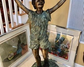 Bronze sculpture of boy with arms raised 