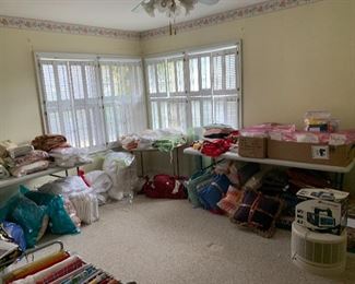 Room full of linens...bedspreads, blankets, curtains, tablecloths and decorative pillows
