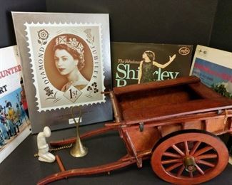 Collector’s edition of the Queen's photographs throught the years along with some of her favorite vinyls. There is also a decorative wooden cart, a soapstone figurine, and a brass bell. All favorites of the Queen. Are you a fan of The Crown? The collector’s edition photographs feature pictures from her coronation!

https://ctbids.com/#!/description/share/753053