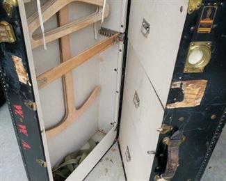 Now this is something you don’t see every day.

This is an antique steamer trunk made by Oshkosh. The trunk has a patent on inside stamped March 16, 1915. Trunk is black with various stickers from travel destinations. Brass clasp made by Yale. When you open trunk it reveals 3 drawers on one side and the other side has wooden hangers and telescoping rods that stick out to hold your clothing. 

Click here to read about the history of Oshkosh Trunks Trunk measurements 36"x13"x21" https://ctbids.com/#!/description/share/753051