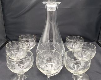 Floral etched decanter measures 13 1/2"H and 4"L and seven matching wine glasses measure 5 1/2"H x 3"L.

https://ctbids.com/#!/description/share/752891