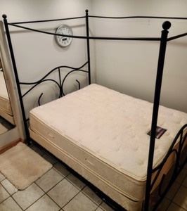 Queen Canopy Bed. The top piece looks to be slightly bent, but in otherwise good shape. The winning bidder is not required to take the mattress. Frame measures 60” wide, 84” long and 80” high. 