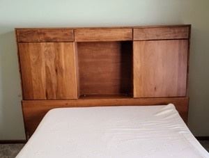 Wooden King Size Headboard with great storage. The mattress pictured is not included. The rails are missing, but a bed can easily be pushed up next to it. Measures 78.5” wide, 12” deep and 59.5” high.