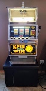 pin and Win Slot Machine. The top glass piece is broken as pictured. There are multiple keys that fit the machine, however, unable to determine the correct set. Measures 22” wide, 21” deep and 65” high.