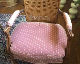 Cane chair with pink floral fabric.