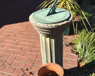 Sundial on stand and tomato planter.