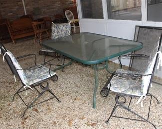 iron and glass patio table and three chairs