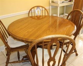 solid wood; not an antique, maybe mid-80-'s; 48" round plus 2 12" leaves; six chairs