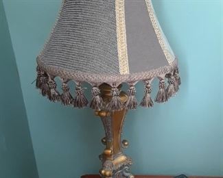 Ornate lamp base with fringed shade