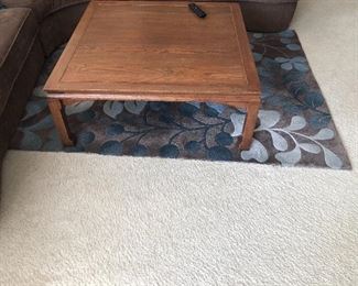 Living room coffee table and sable colored rug with blue accents