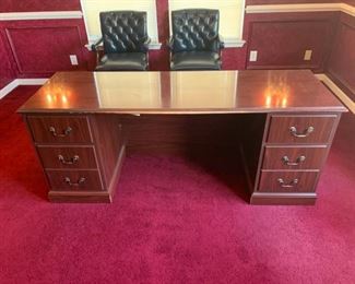 An executive office desk with 4 functional drawers and minimal scratches on some of the edges of the desk and drawers. 72x24x29 *chairs in background are not included. https://ctbids.com/#!/description/share/755994