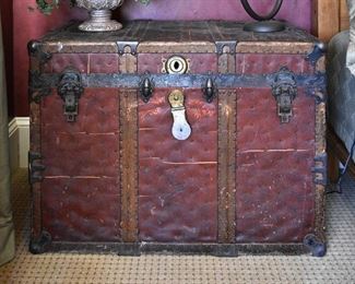 large red leather travel trunk