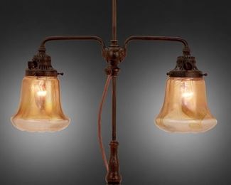 6
A Tiffany Studios Double-Arm Table Lamp
Circa 1902-1919; New York, NY
Each shade signed: L.C.T.; Further signed: S 1176 / S 1181; Base signed: Tiffany Studios / New York / 318
The two gold iridescent Favrile glass shades with pulled feather motif on a patinated bronze double-arm base with engraved swirl and scale motifs, electrified
Overall: 25.5" H x 19" W x 7" D; Each shade: 6" Dia.
Estimate: $4,000 - $6,000