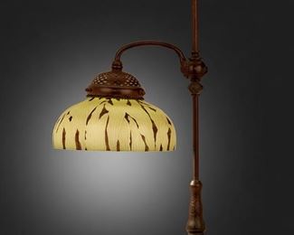 13
A Tiffany Studios Adjustable Table Lamp
1902; New York, NY
Shade signed: L.C.T. / 624; Base signed: [T.G.D.Co. monogram] / Tiffany Studios / New York / 25858
The green and black Favrile glass shade with leaf motif on a patinated bronze adjustable, single swing arm base with bead designs and engraved swirl and scale motifs, electrified
Overall: 25.5" H x 14" Dia.; Shade: 10" Dia.
Estimate: $3,000 - $5,000