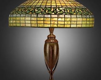 12
A Tiffany Studios "Vine Border" Table Lamp
Circa 1902-1919; New York, NY
Shade signed: Tiffany Studios / New York / 1470; Base signed: Tiffany Studios / New York / 441 / [T.S. monogram]
The green and blue leaded glass "Vine Border" shade on a three-light patinated bronze narrow urn-form "Greek" base, electrified
Overall: 21.5" H x 18" Dia.
Estimate: $8,000 - $12,000