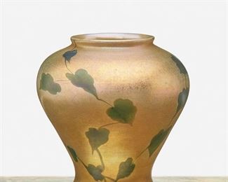 22
A L.C. Tiffany Favrile Glass Leaf And Vine Vase
1912; New York, NY
Signed: L.C. Tiffany / Favrile / 2795 G
The wide-shouldered gold iridescent Favrile glass vase with green iridescent leaf and vine motif
6.5" H x 6" Dia.
Estimate: $800 - $1,200