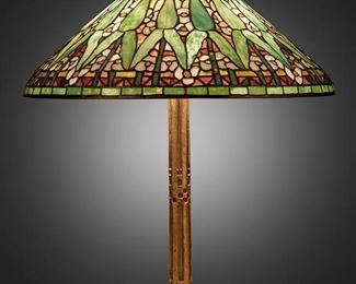 23
A Tiffany Studios "Arrowroot" Table Lamp
First-quarter 20th Century; New York, NY
Shade signed: Tiffany Studios / New York; Base signed: Tiffany Studios / New York / 528
The polychrome leaded glass "Arrowroot" shade on a three-light gilt-bronze "Fifteenth Century" base with straight column and incised square patterning, electrified
Overall: 25" H x 20.75" Dia.
Estimate: $30,000 - $40,000