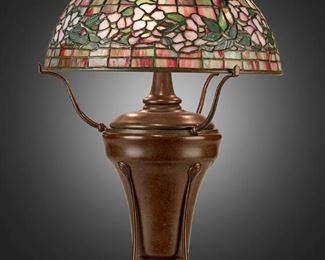 A Tiffany Studios "Dogwood" table lamp
27
A Tiffany Studios "Dogwood" Table Lamp
Late 1904/early 1905; New York, NY
Shade signed: Tiffany Studios / New York / 1553-6; Base signed: Tiffany Studios / New York / 7876
The pink and green leaded glass "Dogwood" banded shade on a three-light patinated bronze urn-form converted oil lamp base, electrified
Overall: 21" H x 14" Dia.
Estimate: $8,000 - $12,000