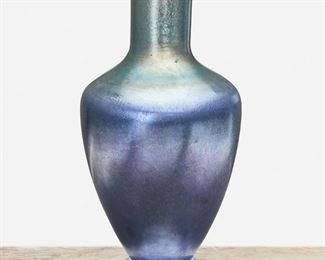 29
A Blue L.C. Tiffany Favrile Glass Vase
1918; New York, NY
Signed: L.C. Tiffany / Favrile / 2053 M / [L.C.T. monogram paper label]
The blue iridescent Favrile glass vase with baluster-form body, tall cylindrical neck, and flared lip raised on footed base
16.75" H x 8" Dia.
Estimate: $2,000 - $3,000