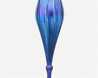 30
A Blue L.C. Tiffany Favrile Glass Floriform Vase
1918; New York, NY
Signed: L.C. Tiffany, Inc. / Favrile / 1526 - 4805 M / [L.C.T. monogram paper label]
The blue iridescent Favrile glass floriform vase with ribbed exterior, scalloped and flared rim, and knopped stem raised on a slightly domed foot
12.5" H x 4.25" Dia.
Estimate: $1,000 - $2,000