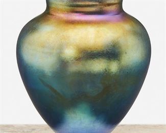 32
A Blue L.C. Tiffany Favrile Glass Vase
Circa 1902-1919; New York, NY
Signed: L.C. Tiffany / Favrile / 1972 / [L.C.T. monogram paper label]
The urn-form blue iridescent Favrile glass vase with tapered foot
6.5" H x 6" Dia.
Estimate: $1,000 - $1,500