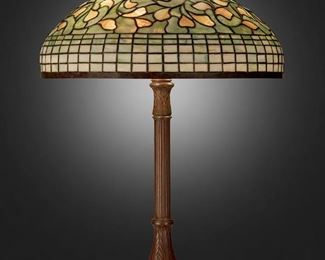 37
A Tiffany Studios "Vine Ornament" Table Lamp
Circa 1902-1919; New York, NY
Shade signed: Tiffany Studios / New York; Base signed: Tiffany Studios / New York / 638
The green and yellow leaded glass "Vine Ornament" shade with geometric skirt on a three-light patinated bronze "Library" base with fluted stem, round foot, and floral and leaf motifs, electrified
Overall: 31" H x 20" Dia.
Estimate: $8,000 - $12,000