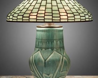 39
A Tiffany Studios Leaded Glass And Rookwood Pottery Table Lamp
First-quarter 20th Century
Shade signed: Tiffany Studios / New York / 1913; Base signed: [Rookwood monogram] / 191 A Z / AM [Albert Cyrus Munson]
The aquamarine-colored Tiffany Studios leaded glass cone shade with stepped brick pattern on a three-light, matte sea green drip glaze Rookwood pottery base with a baluster-form body and incised geometric designs raised on three scrolled foliate feet, electrified
Overall: 23" H x 18" Dia.
Estimate: $7,000 - $9,000