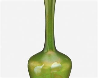 42
A L.C. Tiffany Favrile Glass Leaf And Vine Vase
1907; New York, NY
Signed: L.C.T. / 5703 B
The green iridescent Favrile glass vase with slender cylindrical neck, flared rim, and bulbous body decorated with blue iridescent leaf and vine motif
13.5" H x 5.75" Dia.
Estimate: $1,000 - $1,500