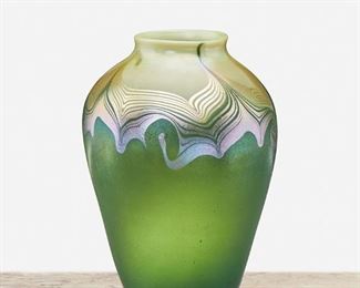47
A L.C. Tiffany Favrile Glass Vase
1902; New York, NY
Signed: L.C.T. / Q 4494
The urn-form Favrile glass vase with green iridescent body, cream iridescent neck, and pulled feather transition
6.5" H x 4.5" Dia.
Estimate: $600 - $800
