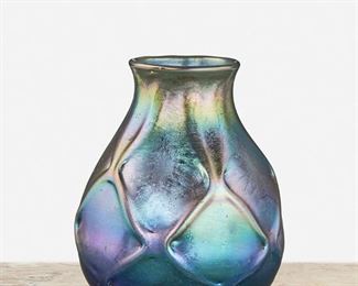 54
A Blue L.C. Tiffany Favrile Glass Vase
1902; New York, NY
Signed: L.C.T. / Q 9251
The blue iridescent Favrile glass vase with globular body, flared lip, and low relief lattice motif
5.5" H x 4.75" Dia.
Estimate: $700 - $900