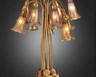 60
A Tiffany Studios Ten-Light "Pond-Lily" Table Lamp
Circa 1902-1919; New York, NY
Each shade signed: L.C.T.; Base signed: Tiffany Studios / New York / 381
The gold-finished bronze "Pond-Lily" base designed with lily pads issuing a drop cluster of ten gold iridescent Favrile glass "Blossom" shades, electrified
21" H x 14" Dia.
Estimate: $10,000 - $15,000