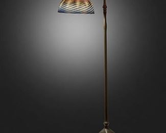 63
A Tiffany Studios Counter-Balance Floor Lamp
Circa 1902-1919; New York, NY
Shade signed: L.C.T. / Favrile; Base signed: Tiffany Studios / New York / 468
The blue iridescent "Wave" Favrile glass shade with tones of pink, yellow, and green on a single-light patinated bronze counter-balance base with plain narrow stem, weighted ball in a foliate cradle, and adjustable head raised on five curved legs with spade feet, electrified
Overall: 54" H x 16" Dia.; Shade: 10.25" Dia.
Estimate: $6,000 - $8,000